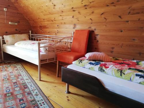 TrahüttenDa Tizzi的小屋内一间卧室配有两张床和一把椅子