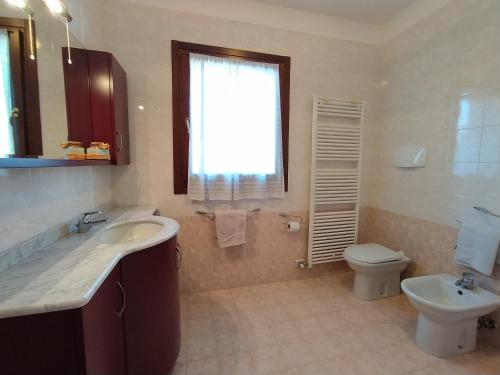 卡多涅赫Appartamento a Cadoneghe Storica的一间带水槽和卫生间的浴室以及窗户。