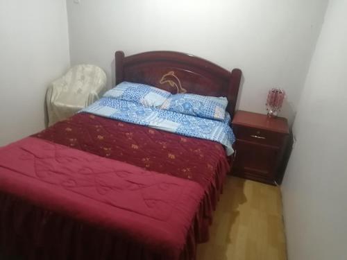 基多艾斯克旗基多旅馆的一间卧室配有一张带红色床罩和床头柜的床