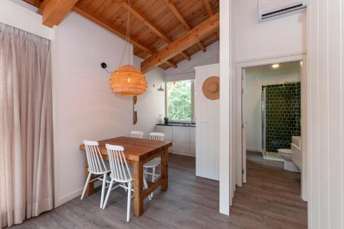 UrzelinaCabanas da Viscondessa的厨房以及带木桌和椅子的用餐室。