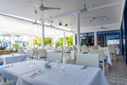 阿依纳帕Anonymous Beach Hotel (Adults 16+)的餐厅设有白色的桌椅和白色的桌椅