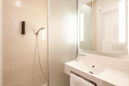 圣但尼B&B HOTEL Saint-Denis Porte de Paris的带淋浴、盥洗盆和镜子的浴室