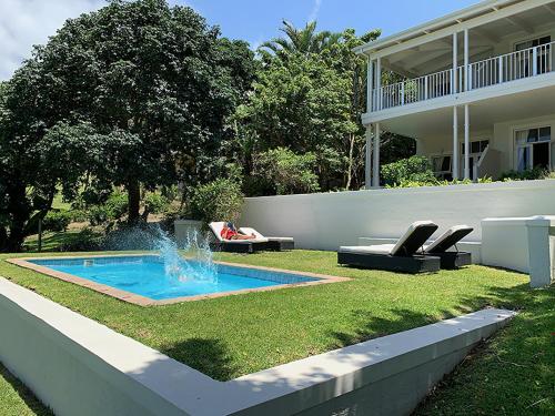 绍斯布鲁姆珊瑚树殖民地住宿加早餐酒店的一座房子的庭院里一个带喷泉的游泳池
