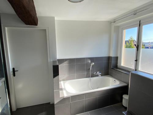 艾斯登Authentic Stays - 6p-maisonette的带窗户的浴室内的白色浴缸
