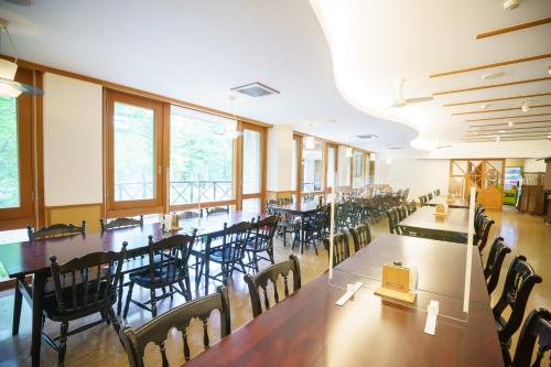 松本The Parklodge Kamikochi的用餐室设有桌椅和窗户。