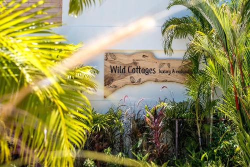 拉迈Wild Cottages Luxury and Natural - SHA Extra Plus Certified的展示了读到野生的哈里福尼亚花园通道的标志