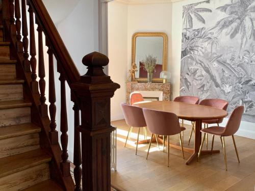 维希La Villégiature的用餐室配有木桌和粉红色椅子