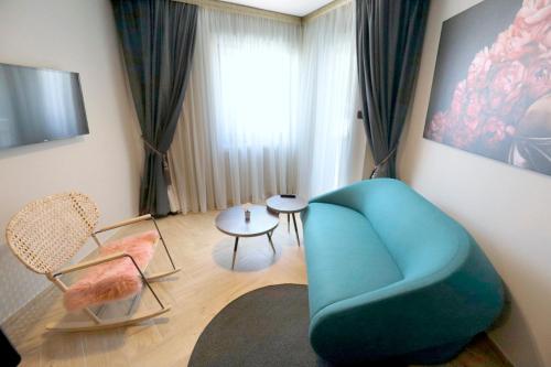 巴什卡沃达维利卡公寓式酒店的客厅配有蓝色椅子和桌子