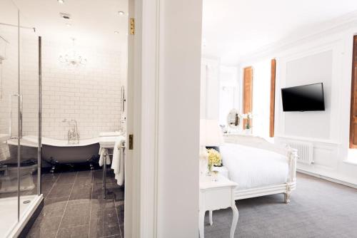 斯坦利比米什大厅乡村别墅BW精选酒店的带浴缸的白色浴室和电视。