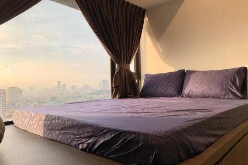 马六甲Imperio,Res - Melaka Raya -- Comfy -- Sunset View的窗户客房内的一张带紫色床单的床