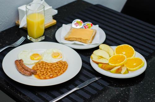 马普托Residencial Horizonte 2的桌上的两盘早餐食品,包括橙子和鸡蛋