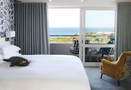 赫曼努斯One Marine Drive Boutique Hotel & Spa by The Living Journey Collection的酒店客房设有一张床,享有海景。