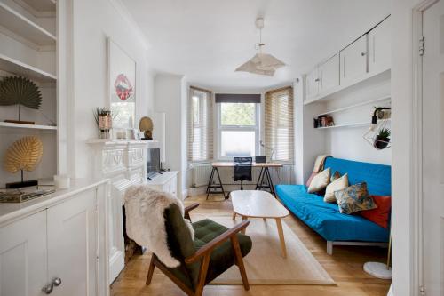 伦敦Pass the Keys - Beautiful stylish flat in South West London的客厅配有蓝色的沙发和桌子