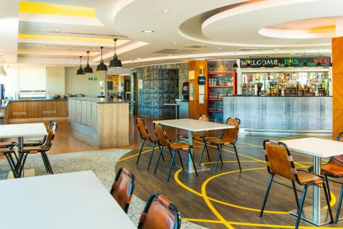 比肯希尔ibis Styles Birmingham NEC & Airport的一间带桌椅的餐厅和一间酒吧
