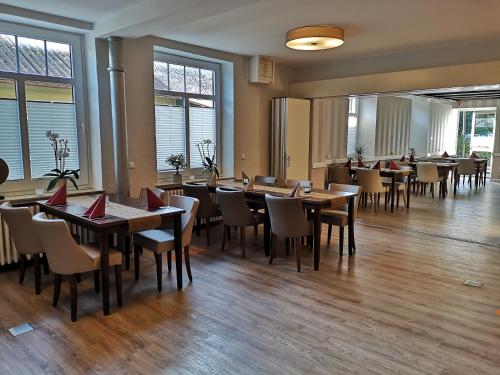 SteyerbergHotel Steyerberger Hof的餐厅设有木桌、椅子和窗户。