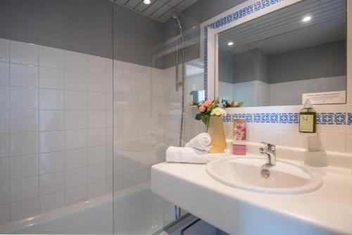 卡庞特拉Hotel du Forum的浴室配有盥洗盆、镜子和浴缸