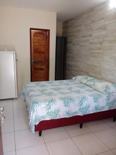 加利纽斯Pousada Chalé Mar Rio的一间卧室配有床和冰箱