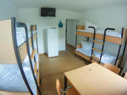 汉堡Hostel & Monteurzimmer bei Hansezimmer的宿舍间设有双层床、桌子和书桌。