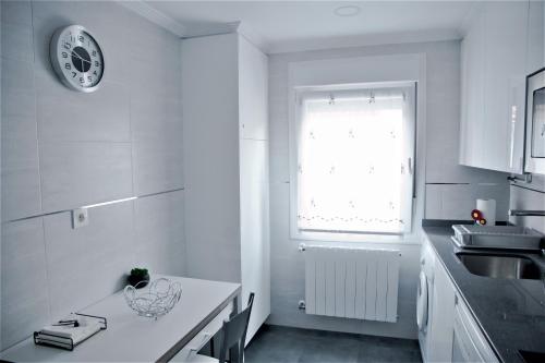 波图加莱特Zubia Home Portugalete - Impecable- 3 min metro Bilbao的白色的厨房设有水槽和窗户
