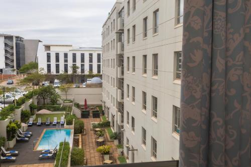 德班德班乌兰加智选假日酒店的从带游泳池的大楼的阳台上可欣赏到风景