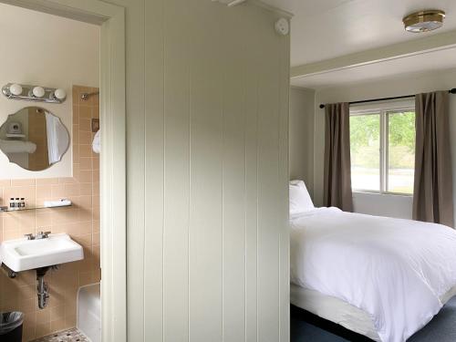AlgomaThe River Hills Motel - Algoma, WI - Near Door County的一间卧室配有床、水槽和窗户