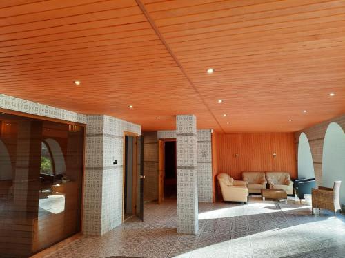 KabileMeždzirnas Country House & SPA的客厅设有木制天花板和沙发。