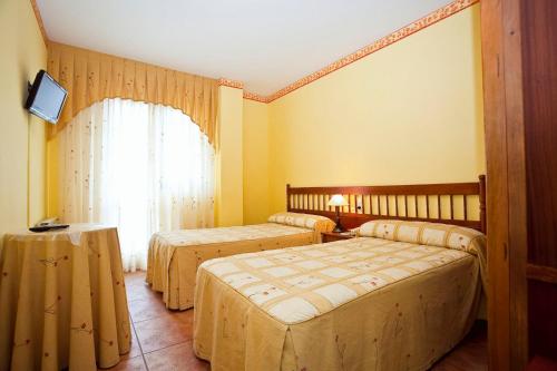 圣维森特-德拉巴尔克拉道路旅馆的酒店客房设有两张床和窗户。