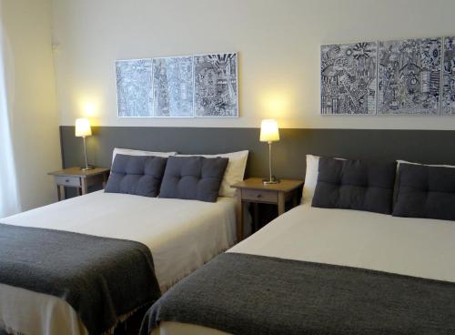 巴塞罗那埃拉尼诺旅馆的配有2盏灯的酒店客房的2张床