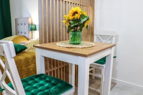 比亚韦斯托克Apartament Podlaskidron的一张桌子,上面有花瓶,上面有向日葵