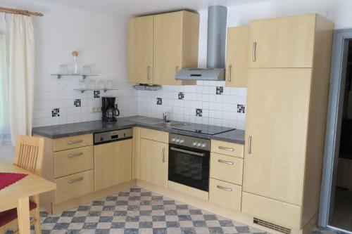 巴德加斯坦Appartment Brigitte的厨房配有木制橱柜和炉灶烤箱。