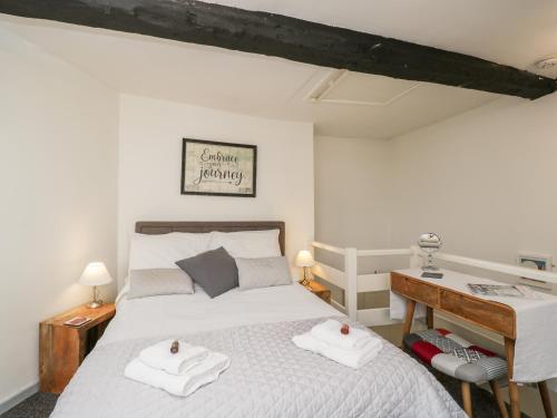 伍斯特Cobblers Cottage的一间卧室配有床和一张带毛巾的书桌