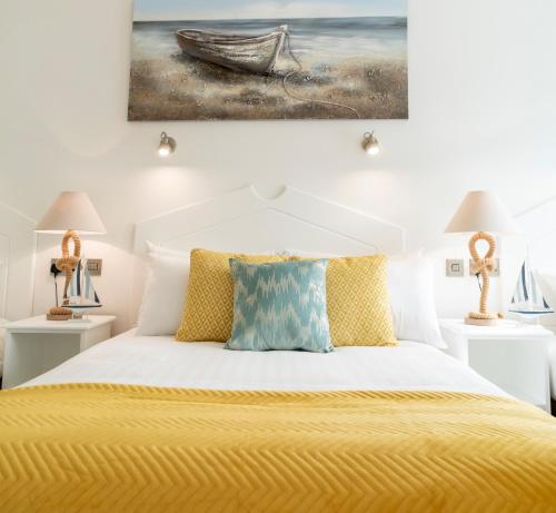 特拉莫尔The Addresse on the Beach的卧室配有一张黄色的床,墙上挂着一幅画