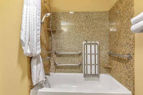 弗赖拉辛弗里斯科康福特茵套房酒店的浴室配有白色浴缸和淋浴。