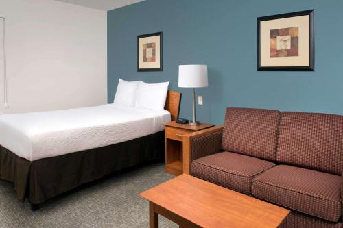 盖恩斯维尔盖恩斯维尔伍德斯普林I-75酒店的酒店客房,配有床和沙发