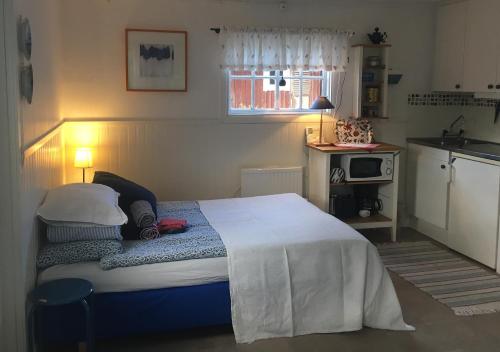 克里斯蒂娜港Lillstugan Elofstorp的一间卧室配有一张床和一个小厨房