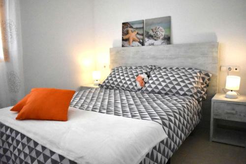 卡尔佩ROCASOL - Beach的一间卧室配有一张黑色和白色的床,并提供橙色枕头。