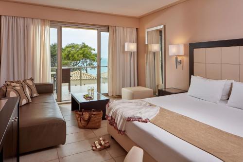 KompítsionAtlantica Grand Mediterraneo Resort - Adults Only的酒店客房设有一张大床和一张沙发。