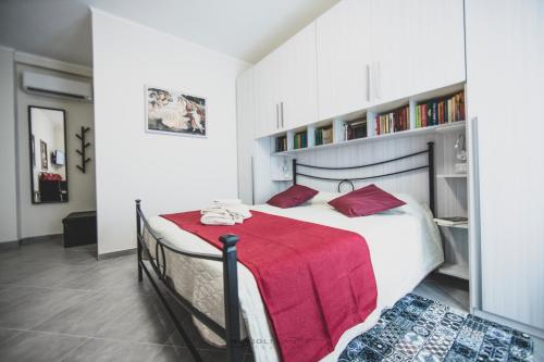 曼托瓦ART & BOOKS bed and breakfast的一间卧室配有一张带红色毯子的大床