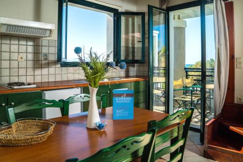 普拉塔尼亚斯阿尔基奥尼德斯海滨酒店的厨房配有带花瓶的桌子