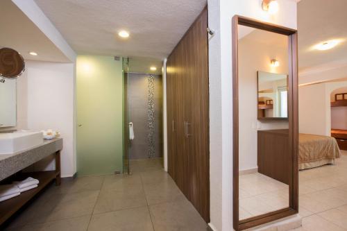 巴亚尔塔港Crown Paradise Club All Inclusive的带淋浴、盥洗盆和镜子的浴室