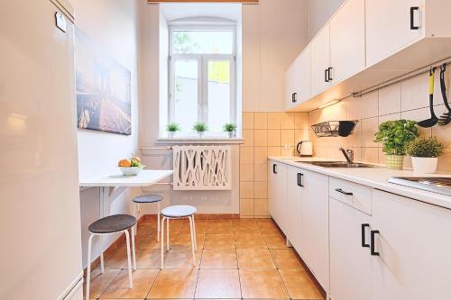 罗兹deLux3的厨房配有白色橱柜和2把凳子