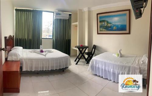 阿塔卡梅斯Hotel Rosmarg的酒店客房设有两张床和一张桌子。