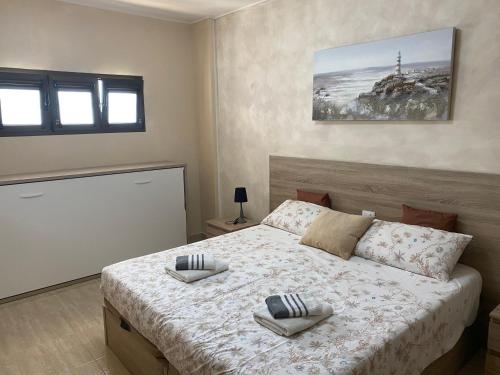 圣巴托洛梅Apartamento Tobias Agaete Parque Playa del Ingles的一间卧室配有一张床,上面有两条毛巾
