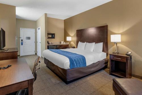 布赖恩特Comfort Inn & Suites Bryant - Benton的酒店客房设有一张大床和一张书桌。