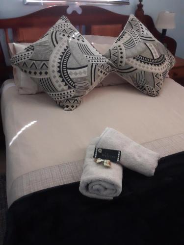 斯托姆勒菲Nadine's Self-Catering Accommodation的一张带毛巾和枕头的床