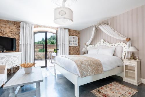 Malataverne圣殿骑士宝藏酒店的卧室设有白色的床和大窗户