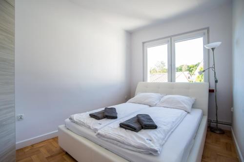 科沃布热格Apartamenty Robi的白色卧室,配有带毛巾的床
