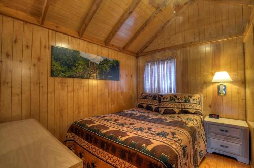 布赖森城河湾汽车旅馆的木制客房内的一间卧室,配有一张床