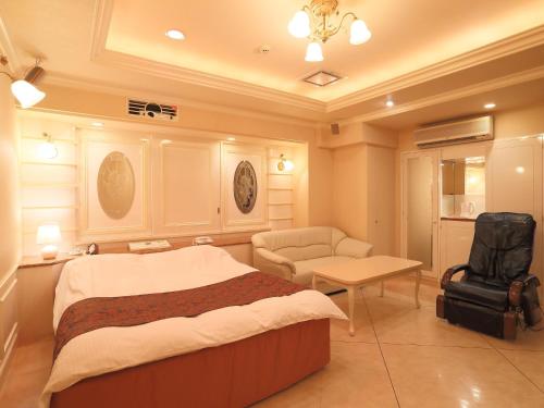 川越町Hotel Fine Garden Kuwana的一间卧室配有一张床、一把椅子和一张桌子