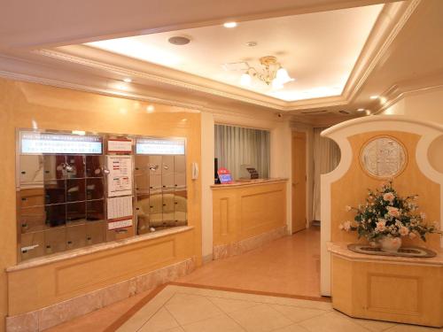 川越町Hotel Fine Garden Kuwana的大厅,带窗户和鲜花的建筑